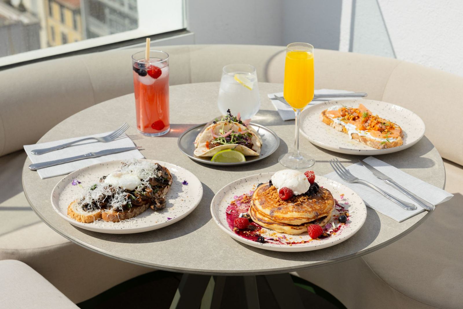 Mesa compartida con cócteles y brunch en la terraza de NUVÓ